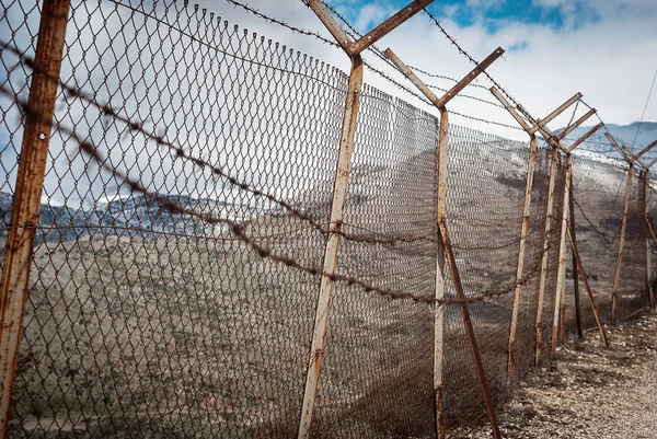 Barbed wire on fence around Israeli settlements on Golan heights, Israel. Protective fencing of specially protected object of barbed wire. Stamped barbed wire