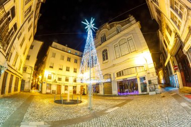 Yılbaşı gecesi, eski bir Avrupa meydanında, x-kitlesi olan bir ağaç manzarası
