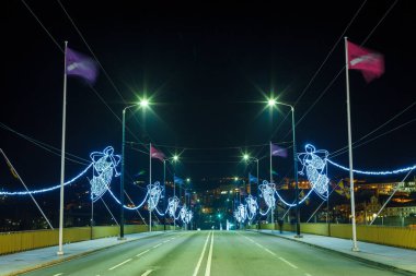 Noel gecesinde çelenkten yapılmış meleklerle dolu bir köprüde