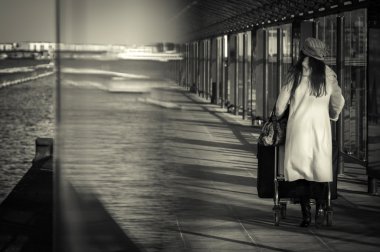 Cam tünel üzerinden yürüyen bir Bagaj kadınla. 