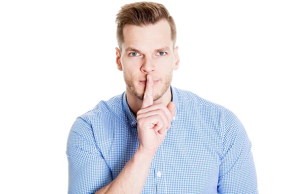 Uomo d'affari con un dito sulle labbra che chiede silenzio — Foto Stock