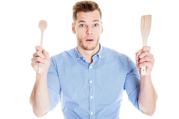 Divertido joven con herramientas de cocina aislado en blanco Imagen De Stock