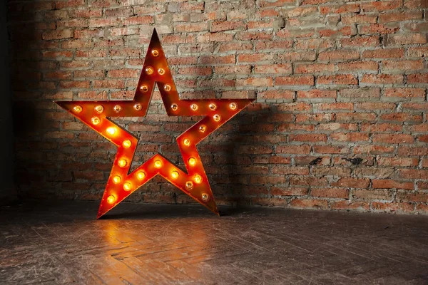 Decorative star with lamps on a background of brick wall. Modern grungy interior — Stock Photo, Image