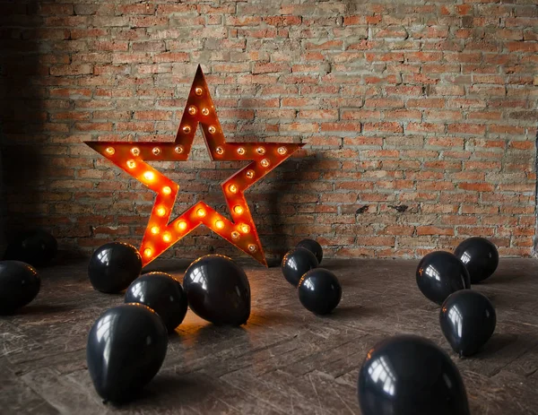 Decorative star with lamps and black balloons on the floor. Modern grungy interior. Space for the Halloween. — Stock Photo, Image