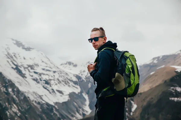 Joven con mochila de pie en la cima de una montaña — Foto de Stock