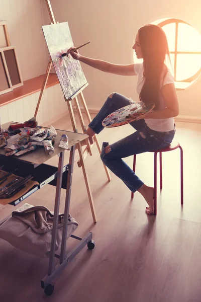 Kvinnelig kunstner som arbeider med maling i studio . – stockfoto