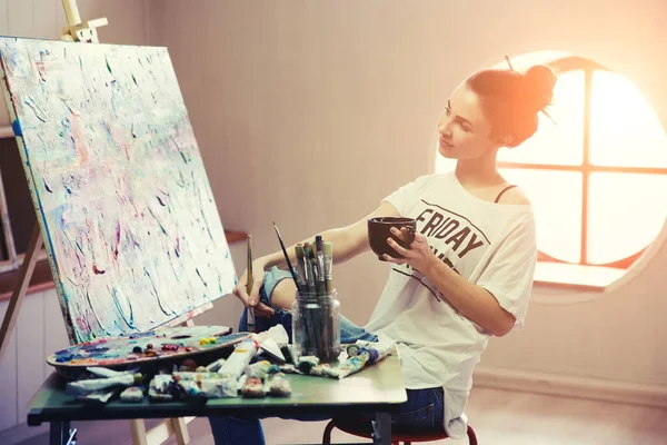 Artista feminina trabalhando na pintura no estúdio . — Fotografia de Stock