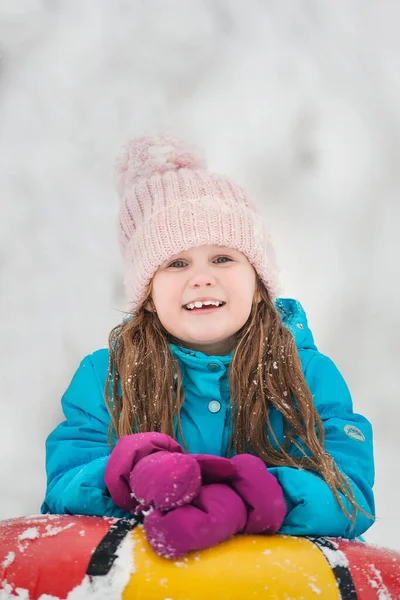 Chica divirtiéndose en la nieve tube.Girl está montando un tubo . — Foto de Stock