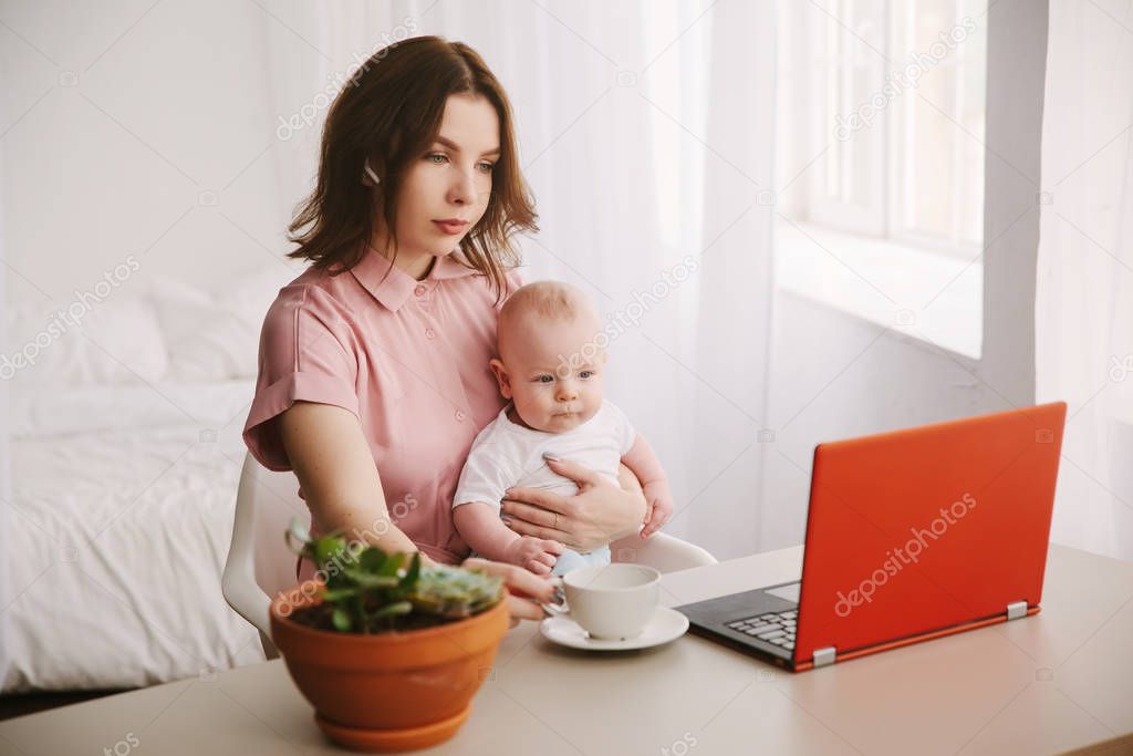 freelance and motherhood concept - working mother baby boy and laptop computer at home office