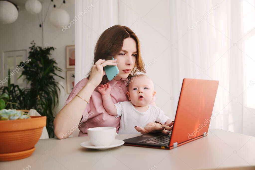 mom and baby. a young mother working with laptop in and talk on the phone.