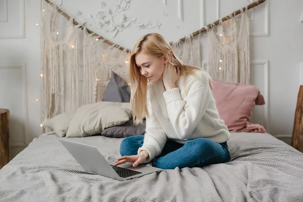 Flicka student studera online med skype lärare, glad ung kvinna titta på laptop sitta på sängen hemma. — Stockfoto