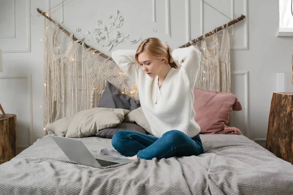 Flicka student studera online med skype lärare, glad ung kvinna titta på laptop sitta på sängen hemma. — Stockfoto