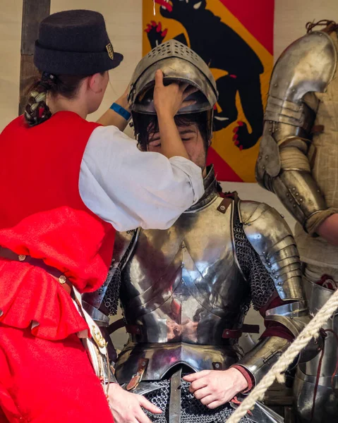 Um escudeiro ajuda um cavaleiro a tirar o capacete depois de uma batalha. — Fotografia de Stock