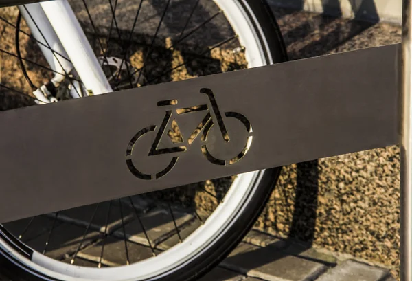 Um estacionamento de bicicleta no estacionamento contra uma parede — Fotografia de Stock