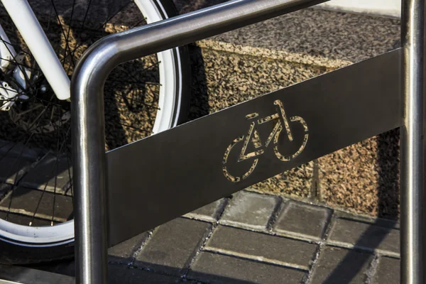 Um estacionamento de bicicleta no estacionamento contra uma parede — Fotografia de Stock