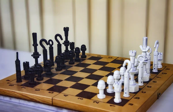 Разрисованные черно-белые шурупы, доски, крючки, клатчи, держатели и фастфуды и другая мелкая посуда на шахматной доске, используемая в качестве шахматных фигур — стоковое фото