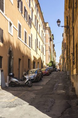 Roma, İtalya 'da sıcak yaz gününde arabalı, motosikletli boş dar resimli şehir merkezi caddesi.