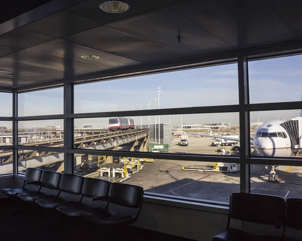 Area d'attesa dell'aeroporto con un aereo che si prepara a un volo e terminal dell'aeroporto Treno di transito su uno sfondo, Chicago — Foto Stock