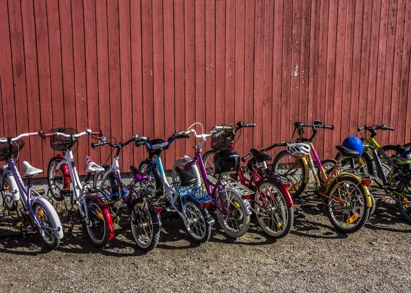 O estacionamento para crianças bicicletas perto de uma parede de madeira em uma cidade europeia perto do ensino fundamental . — Fotografia de Stock