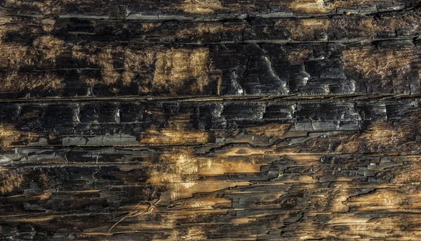 Пепел частично сгоревшей деревянной доски, поврежденной пожаром — стоковое фото