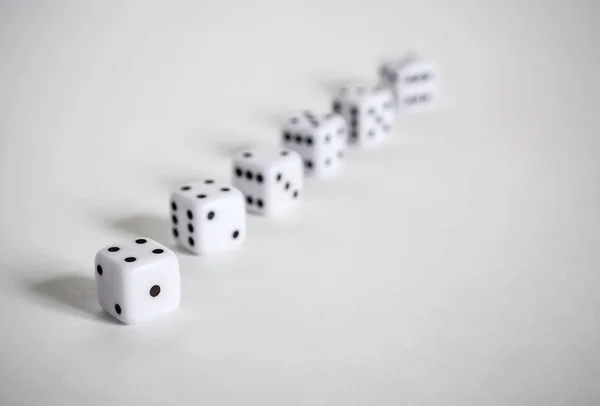 White dices in a row or scattered on white background soft focus — Stock Photo, Image