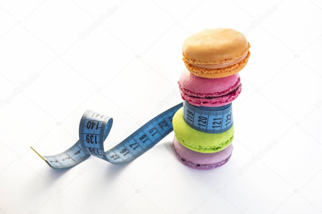 Colorful macaroons and blue meter tape, concept of healthy eating and nutrition