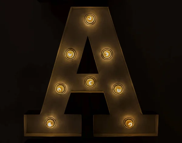 electric bulb sign of a first letter of alphabet A on a black background