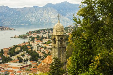 Karadağ, Kotor, 09 Ekim 2019. Eski kasabanın eski Kotor duvarlarında ve Kotor Kalesi 'nin (St John Kalesi) antik duvarlarında ve Kotor kasabasının yamacındaki dağlarda bulunan Kurtuluş Anıtı Kilisesi' nin (Bas-Relivation) manzarası. Unesco.