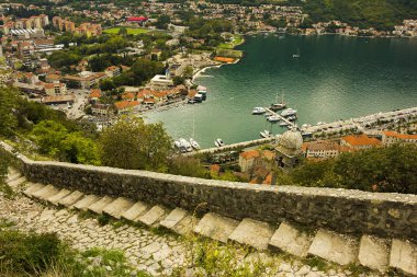 Karadağ, Kotor, 09 Ekim 2019. Eski kasabanın eski Kotor duvarlarında ve Kotor Kalesi 'nin (St John Kalesi) antik duvarlarında ve Kotor kasabasının yamacındaki dağlarda bulunan Kurtuluş Anıtı Kilisesi' nin (Bas-Relivation) manzarası. Unesco.