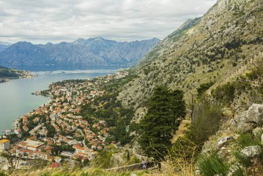 Karadağ, Kotor, 09 Ekim 2019. Eski kasabanın eski Kotor duvarlarında ve Kotor Kalesi 'nin (St John Kalesi) antik duvarlarında ve Kotor kasabasının yamacındaki dağlarda bulunan Kurtuluş Anıtı Kilisesi' nin (Bas-Relivation) manzarası. Unesco.