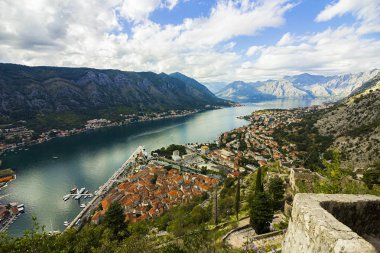 Karadağ, Kotor, 09 Ekim 2019. Eski kasabanın eski Kotor duvarlarında ve Kotor Kalesi 'nin (St John Kalesi) antik duvarlarında ve Kotor kasabasının yamacındaki dağlarda bulunan Kurtuluş Anıtı Kilisesi' nin (Bas-Relivation) manzarası. Unesco.