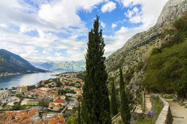 Karadağ, Kotor, 09 Ekim 2019. Eski kasabanın eski Kotor duvarlarında ve Kotor Kalesi 'nin (St John Kalesi) antik duvarlarında ve Kotor kasabasının yamacındaki dağlarda bulunan Kurtuluş Anıtı Kilisesi' nin (Bas-Relivation) manzarası. Unesco.