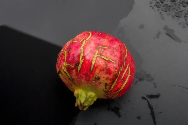 Zeer Rijpe Granaatappel Fruit Met Gebarsten Schil Natte Zwarte Ondergrond — Stockfoto