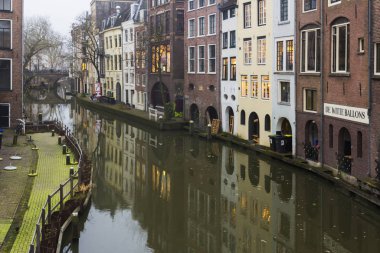  Utrecht, Hollanda, 21 Ocak 2020. Utrecht 'in merkezindeki kanal boyunca çift yay taş köprü. Misty Evening, kanalın gece manzarası, eski Hollandalı evler, kanal boyunca bisikletler.