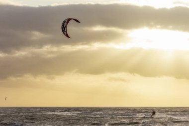 Günbatımında rüzgârlı bir kış gününde kuzey sahili manzarası, millet, uçurtma. Noordwijk, Hollanda