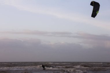 Günbatımında rüzgârlı bir kış gününde kuzey sahili manzarası, millet, uçurtma. Noordwijk, Hollanda