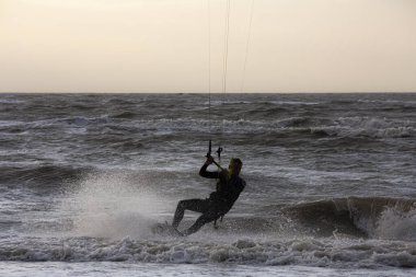 Günbatımında rüzgârlı bir kış gününde kuzey sahili manzarası, millet, uçurtma. Noordwijk, Hollanda