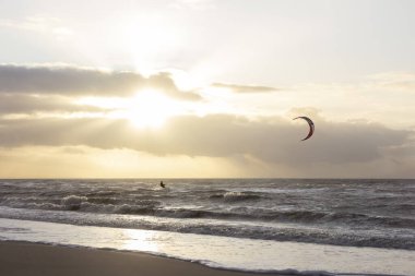 Günbatımında rüzgârlı bir kış gününde kuzey sahili manzarası, millet, uçurtma. Noordwijk, Hollanda