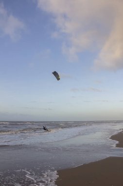 Günbatımında rüzgârlı bir kış gününde kuzey sahili manzarası, millet, uçurtma. Noordwijk, Hollanda