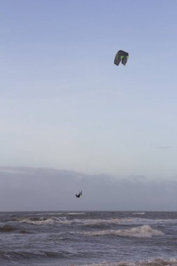 Günbatımında rüzgârlı bir kış gününde kuzey sahili manzarası, millet, uçurtma. Noordwijk, Hollanda