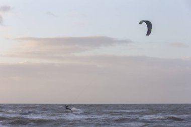Günbatımında rüzgârlı bir kış gününde kuzey sahili manzarası, millet, uçurtma. Noordwijk, Hollanda
