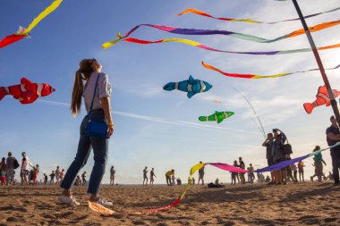 Saint Petersburg, Rusya - 31 Ağustos 2019. İnsanlar etrafta dolanıyor, renkli kurdeleler ve uçurtma figürleri direkte asılı ve mavi gökyüzü arka planında uçuyor, uçurtma festivali