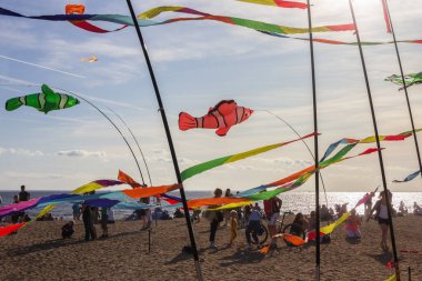 Saint Petersburg, Rusya - 31 Ağustos 2019. İnsanlar etrafta dolanıyor, renkli kurdeleler ve uçurtma figürleri direkte asılı ve mavi gökyüzü arka planında uçuyor, uçurtma festivali