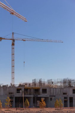 Üniformalı sanayi işçileri ve inşaatçılar inşaat sahasına beton döküp destek leşi yığıyorlar.