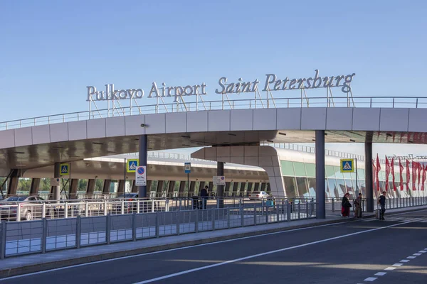 Saint-PETERSBURG, RUSSIA - 24 Haziran 2019: Pulkovo havaalanının kalkış bölgesinin rampasında. Pulkovo Uluslararası Havalimanı - dış bina. Valizli turistler.