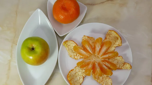 Натюрморт з очищеним мандарином і яблуком — стокове фото