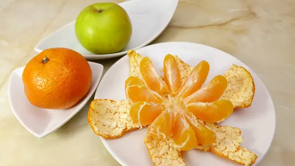 Натюрморт з очищеним мандарином і яблуком — стокове фото