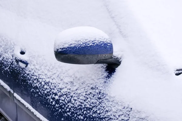 Snötäckt bil på en öppen parkering — Stockfoto