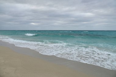 Bulutlu gökyüzü ile kum plaj