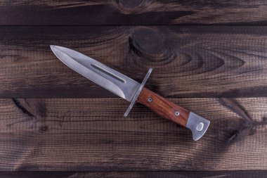 Ahşap arka plan üzerinde bıçak mücadele. Kalaşnikof süngü